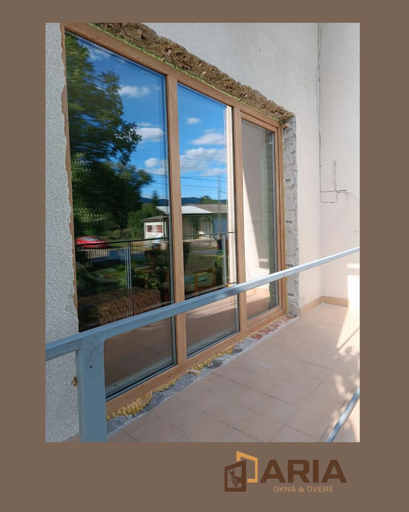 Veľké presklené okno s odrazom oblohy a hôr po montáži